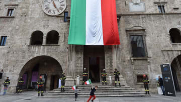ASCOLI PICENO, ITALY - DECEMBER 04: Children play waving the Italian flag during the performance of the firefighters of Ascoli Piceno in Piazza del Popolo on the occasion of the feast of Santa Barbara protector of the firefighters on December 4, 2022 in Ascoli Piceno, Italy. Santa Barbara is the Patron Saint of the Italian firefighters. (Photo by Giuseppe Bellini/Getty Images)