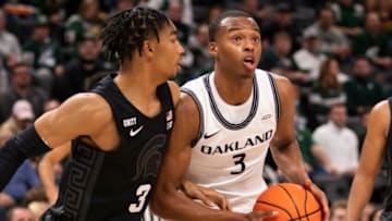 Dec 21, 2021; Detroit, Michigan, USA; Oakland Golden Grizzlies forward Micah Parrish (3) gets defended by Michigan State Spartans guard Jaden Akins (3) during the first half at Little Caesars Arena. Mandatory Credit: Raj Mehta-USA TODAY Sports