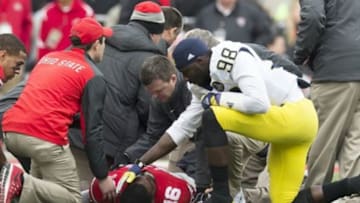 Nov 29, 2014; Columbus, OH, USA; Michigan Wolverines quarterback Devin Gardner (98) checks on Ohio State Buckeyes quarterback J.T. Barrett (16) after Barret was injured at Ohio Stadium. Mandatory Credit: Greg Bartram-USA TODAY Sports