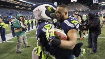Dec 4, 2016; Seattle, WA, USA; Seattle Seahawks running back Thomas Rawls (34) is hugged by a team mascot as he heads to the locker room after a game against the Carolina Panthers at CenturyLink Field. The Seahawks won 40-7. Mandatory Credit: Troy Wayrynen-USA TODAY Sports