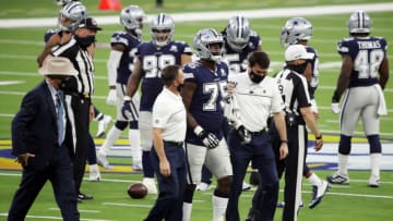INGLEWOOD, CALIFORNIA - SEPTEMBER 13: Cameron Erving #75 of the Dallas Cowboys is helped off the field after suffering an apparent injury during the second quarter against the Los Angeles Rams at SoFi Stadium on September 13, 2020 in Inglewood, California. (Photo by Katelyn Mulcahy/Getty Images)