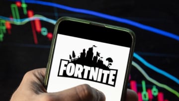 CHINA - 2021/12/09: In this photo illustration the online video game by Epic Games company Fortnite logo seen displayed on a smartphone with an economic stock exchange index graph in the background. (Photo Illustration by Budrul Chukrut/SOPA Images/LightRocket via Getty Images)