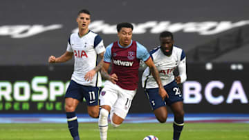 LONDON, ENGLAND - FEBRUARY 21: Jesse Lingard of West Ham United runs with the ball whilst under pressure from Tanguy Ndombele (R) and Erik Lamela of Tottenham Hotspur during the Premier League match between West Ham United and Tottenham Hotspur at London Stadium on February 21, 2021 in London, England. Sporting stadiums around the UK remain under strict restrictions due to the Coronavirus Pandemic as Government social distancing laws prohibit fans inside venues resulting in games being played behind closed doors. (Photo by Neil Hall - Pool/Getty Images)