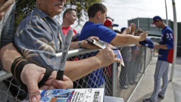 Fans wait for Texas Rangers pitcher Cole Hamels (35) to sign for them during spring training on Saturday, Feb. 17, in Surprise, Ariz. (Paul Moseley/Fort Worth Star-Telegram/TNS via Getty Images)