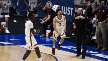 NASHVILLE, TN - MARCH 12: Juwan Gary #4 and Jahvon Quinerly #13 of the Alabama Crimson Tide celebrate connecting on a alley oop dunk as head coach Ben Howland of the Mississippi State Bulldogs calls a timeout during the first half of their quarterfinal game in the SEC Men's Basketball Tournament at Bridgestone Arena on March 12, 2021 in Nashville, Tennessee. (Photo by Brett Carlsen/Getty Images)