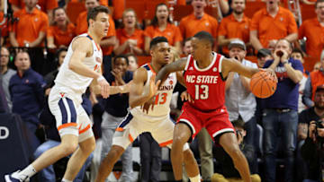 CHARLOTTESVILLE, VA - JANUARY 20: Francisco Caffaro #22 and Casey Morsell #13 of the Virginia Cavaliers defend C.J. Bryce #13 of the North Carolina State Wolfpack in the second half during a game at John Paul Jones Arena on January 20, 2020 in Charlottesville, Virginia. (Photo by Ryan M. Kelly/Getty Images)