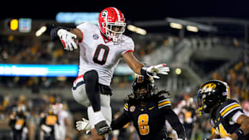 COLUMBIA, MO - OCTOBER 01: Darnell Washington #0 of the Georgia Bulldogs leaps while running the ball against Ty'Ron Hopper #8 and Kris Abrams-Draine #14 of the Missouri Tigers during the second half at Faurot Field/Memorial Stadium on October 1, 2022 in Columbia, Missouri. (Photo by Jay Biggerstaff/Getty Images)