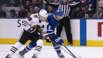 Jan 18, 2020; Toronto, Ontario, CAN; Chicago Blackhawks right wing Patrick Kane (88) battles for a puck against Toronto Maple Leafs defenseman Justin Holl (3) during second period at Scotiabank Arena. Mandatory Credit: Nick Turchiaro-USA TODAY Sports