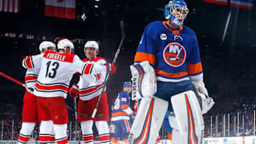 UNIONDALE, NEW YORK - JANUARY 08: Saku Maenalanen #8 of the Carolina Hurricanes is congratulated by his teammates after scoring his first NHL goal during the first period as Thomas Greiss #1 of the New York Islanders reacts at Nassau Veterans Memorial Coliseum on January 08, 2019 in Uniondale, New York. (Photo by Mike Stobe/NHLI via Getty Images)