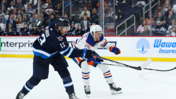 Sep 25, 2023; Winnipeg, Manitoba, CAN; Edmonton Oilers defenseman Philip Broberg (86) tries to check Winnipeg Jets forward Gabriel Vilari (13) during the second period at Canada Life Centre. Mandatory Credit: Terrence Lee-USA TODAY Sports