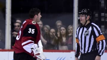 Jan 23, 2016; Glendale, AZ, USA; Arizona Coyotes goalie Louis Domingue (35) argues with NHL referee Evgeny Romasko after giving up a goal in the second period against the Los Angeles Kings at Gila River Arena. Mandatory Credit: Matt Kartozian-USA TODAY Sports