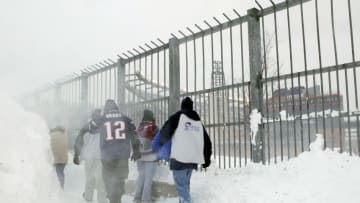 FOXBORO, MA - DECEMBER 7: Fans walk through piles of snow to get to the Miami Dolphins game against the New England Patriots on December 7, 2003 at Gillette Stadium in Foxboro, Massachusetts. (Photo by Ezra Shaw/Getty Images)