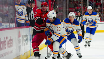 Nov 7, 2023; Raleigh, North Carolina, USA; Buffalo Sabres defensemen ryan Johnson (33) checks Carolina Hurricanes right wing Andrei Svechnikov (37) during the third period at PNC Arena. Mandatory Credit: James Guillory-USA TODAY Sports