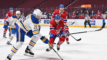 MONTREAL, QC - FEBRUARY 13: Kyle Okposo #21 of the Buffalo Sabres skates the puck against Kale Clague #43 of the Montreal Canadiens during the first period at Centre Bell on February 13, 2022 in Montreal, Canada. (Photo by Minas Panagiotakis/Getty Images)