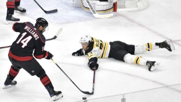 RALEIGH, NORTH CAROLINA - MAY 14: Charlie McAvoy #73 of the Boston Bruins looks for the puck as he slides on the ice against Justin Williams #14 of the Carolina Hurricanes during the first period in Game Three of the Eastern Conference Finals during the 2019 NHL Stanley Cup Playoffs at PNC Arena on May 14, 2019 in Raleigh, North Carolina. (Photo by Grant Halverson/Getty Images)