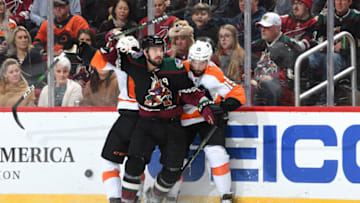 GLENDALE, ARIZONA - JANUARY 04: Brad Richardson #15 of the Arizona Coyotes battles for the puck along the boards with Nicolas Aube-Kubel #62 and Matt Niskanen #15 of the Philadelphia Flyers during the second period of the NHL hockey game at Gila River Arena on January 04, 2020 in Glendale, Arizona. (Photo by Norm Hall/NHLI via Getty Images)