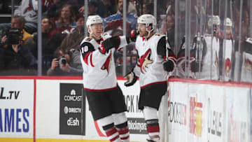 DENVER, COLORADO - OCTOBER 12: Nick Schmaltz #8 of the Arizona Coyotes celebrates with teammate Christian Dvorak #18 after scoring a goal against the Colorado Avalanche at the Pepsi Center on October 12, 2019 in Denver, Colorado.