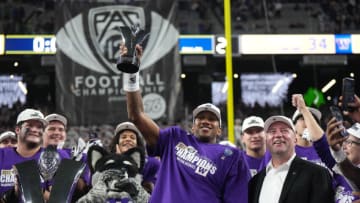 Dec 1, 2023; Las Vegas, NV, USA; Washington Huskies quarterback Michael Penix Jr. (9) holds the the Pac-12 Championship game most valuable player trophy as athletic director Troy Dannen watches after victory over the Oregon Ducks at Allegiant Stadium. Mandatory Credit: Kirby Lee-USA TODAY Sports