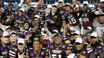 Dec 30, 2015; Charlotte, NC, USA; The Mississippi State Bulldogs pose for a picture with the Belk Bowl trophy after defeating the North Carolina State Wolfpack in the 2015 Belk Bowl at Bank of America Stadium. The Bulldogs defeated the Wolfpack 51-28. Mandatory Credit: Jeremy Brevard-USA TODAY Sports