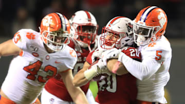 RALEIGH, NORTH CAROLINA - NOVEMBER 09: K.J. Henry #5 of the Clemson Tigers tackles Jordan Houston #20 of the North Carolina State Wolfpack during their game at Carter-Finley Stadium on November 09, 2019 in Raleigh, North Carolina. (Photo by Streeter Lecka/Getty Images)