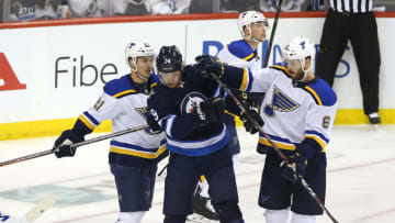 WINNIPEG, MANITOBA - APRIL 18: Joel Edmundson #6 and Tyler Bozak #21 of the St. Louis Blues rough up Patrik Laine #29 of the Winnipeg Jets after a whistle in Game Five of the Western Conference First Round during the 2019 NHL Stanley Cup Playoffs at Bell MTS Place on April 18, 2019 in Winnipeg, Manitoba, Canada. (Photo by Jason Halstead/Getty Images)