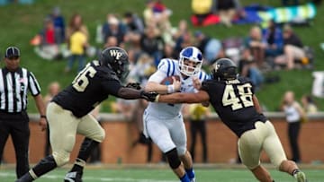 Nov 28, 2015; Winston-Salem, NC, USA; Duke Blue Devils quarterback Thomas Sirk (1) gets tackled by Wake Forest Demon Deacons linebacker Brandon Chubb (48) and defensive lineman Tylor Harris (36) during the fourth quarter at BB&T Field. Duke defeated Wake Forest 27-21. Mandatory Credit: Jeremy Brevard-USA TODAY Sports