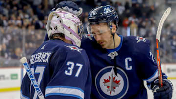 WINNIPEG, MB - NOVEMBER 9: Goaltender Connor Hellebuyck #37 and Blake Wheeler #26 of the Winnipeg Jets celebrate following a 5-2 victory over the Colorado Avalanche at the Bell MTS Place on November 9, 2018 in Winnipeg, Manitoba, Canada. (Photo by Darcy Finley/NHLI via Getty Images)