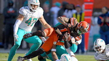 CLEVELAND, OHIO - NOVEMBER 24: Cornerback Ken Crawley #32 and free safety Adrian Colbert #36 of the Miami Dolphins tackle wide receiver Odell Beckham #13 of the Cleveland Browns during the second half at FirstEnergy Stadium on November 24, 2019 in Cleveland, Ohio. The Browns defeated the Dolphins 41-24. (Photo by Jason Miller/Getty Images)
