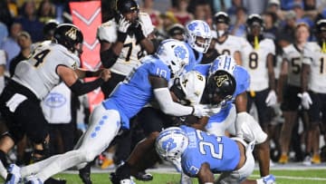 Sep 9, 2023; Chapel Hill, North Carolina, USA; Appalachian State Mountaineers running back Maquel Haywood (28) is tackled by North Carolina Tar Heels defensive lineman Desmond Evans (10) and linebacker Power Echols (23) in the fourth quarter at Kenan Memorial Stadium. Mandatory Credit: Bob Donnan-USA TODAY Sports