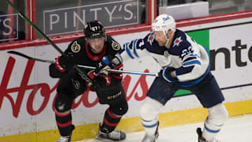 May 3, 2021; Ottawa, Ontario, CAN; Ottawa Senators center Shane Pinto (57) battles with Winnipeg Jets center Trevor Lewis (23) in the third period at the Canadian Tire Centre. Mandatory Credit: Marc DesRosiers-USA TODAY Sports