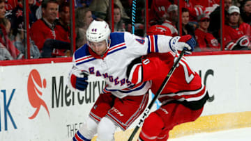 RALEIGH, NC - MARCH 31: Sebastian Aho #20 of the Carolina Hurricanes knocks Neal Pionk #44 of the New York Rangers off the puck during an NHL game on March 31, 2018 at PNC Arena in Raleigh, North Carolina. (Photo by Gregg Forwerck/NHLI via Getty Images)