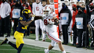 Nov 14, 2020; Ann Arbor, Michigan, USA; Wisconsin Badgers tight end Jake Ferguson (84) stiff arms Michigan Wolverines defensive back Daxton Hill (30) in the second half at Michigan Stadium. Mandatory Credit: Rick Osentoski-USA TODAY Sports