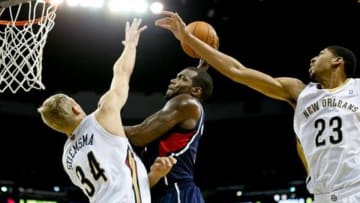 Feb 5, 2014; New Orleans, LA, USA; Atlanta Hawks power forward Paul Millsap (4) dunks over New Orleans Pelicans center Greg Stiemsma (34) and power forward Anthony Davis (23) during the second half of a game at New Orleans Arena. The Pelicans defeated the Hawks 105-100. Mandatory Credit: Derick E. Hingle-USA TODAY Sports