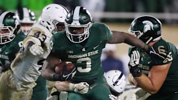 EAST LANSING, MI - NOVEMBER 04: LJ Scott #3 of the Michigan State Spartans battles for yards past Manny Bowen #43 of the Penn State Nittany Lions during the second half at Spartan Stadium on November 4, 2017 in East Lansing, Michigan. Michigan State won the game 27-24. (Photo by Gregory Shamus/Getty Images)
