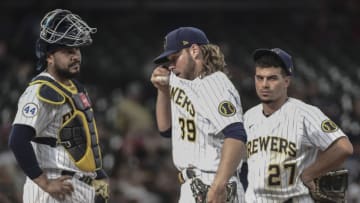 Jun 12, 2021; Milwaukee, Wisconsin, USA; Milwaukee Brewers starting pitcher Corbin Burnes (39) reacts during a pitching change in the fifth inning against the Pittsburgh Pirates as catcher Omar Narvaez (10) and Willy Adames (27) look on at American Family Field. Mandatory Credit: Benny Sieu-USA TODAY Sports