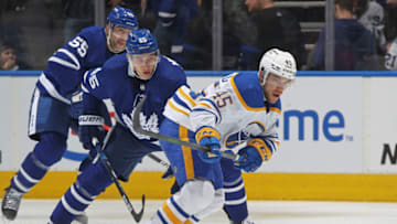 TORONTO, ON - APRIL 12: Casey Fitzgerald #45 of the Buffalo Sabres skates with the puck against Ilya Mikheyev #65 of the Toronto Maple Leafs during an NHL game at Scotiabank Arena on April 12, 2022 in Toronto, Ontario, Canada. (Photo by Claus Andersen/Getty Images)