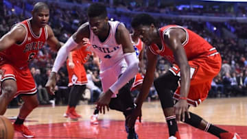 Apr 13, 2016; Chicago, IL, USA; Philadelphia 76ers forward Nerlens Noel (4) and Chicago Bulls guard Justin Holiday (7) attempt to get a loose ball during the second half at the United Center. Mandatory Credit: Mike DiNovo-USA TODAY Sports