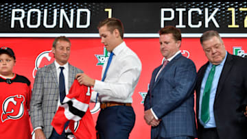 Jun 22, 2018; Dallas, TX, USA; Ty Smith puts on a team jersey after being selected as the number seventeen overall pick to the New Jersey Devils in the first round of the 2018 NHL Draft at American Airlines Center. Mandatory Credit: Jerome Miron-USA TODAY Sports