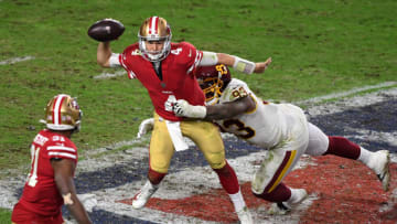GLENDALE, ARIZONA - DECEMBER 13: Quarterback Nick Mullens #4 of the San Francisco 49ers attempts to deliver a pass as he is tackled by defensive tackle Jonathan Allen #93 of the Washington Football Team at State Farm Stadium on December 13, 2020 in Glendale, Arizona. (Photo by Norm Hall/Getty Images)