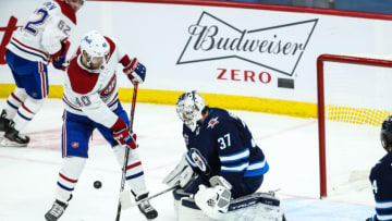 Feb 27, 2021; Winnipeg, Manitoba, CAN; Montreal Canadiens forward Joel Armia (40) misses a rebound off Winnipeg Jets goalie Connor Hellebuyck (37) during the third period at Bell MTS Place. Mandatory Credit: Terrence Lee-USA TODAY Sports