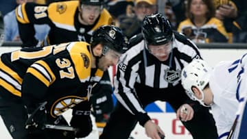 BOSTON, MA - APRIL 12: Boston Bruins center Patrice Bergeron (37) settles in for the face off as linesman Mark Shewchyk (92) instructs Toronto Maple Leafs left wing Zach Hyman (11) during Game 1 of the First Round for the 2018 Stanley Cup Playoffs between the Boston Bruins and the Toronto Maple Leafs on April 12, 2018, at TD Garden in Boston, Massachusetts. The Bruins defeated the Maple Leafs 5-1. (Photo by Fred Kfoury III/Icon Sportswire via Getty Images)