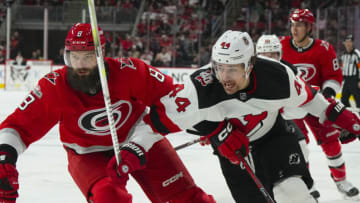 Dec 20, 2022; Raleigh, North Carolina, USA; Carolina Hurricanes defenseman Brent Burns (8) and New Jersey Devils left wing Miles Wood (44) chase after the play during the second period at PNC Arena. Mandatory Credit: James Guillory-USA TODAY Sports