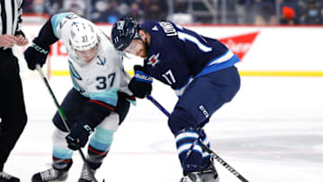 Feb 17, 2022; Winnipeg, Manitoba, CAN; Seattle Kraken center Yanni Gourde (37) and Winnipeg Jets center Adam Lowry (17) face off in the first period at Canada Life Centre. Mandatory Credit: James Carey Lauder-USA TODAY Sports