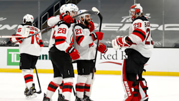 BOSTON, MASSACHUSETTS - FEBRUARY 18: Mackenzie Blackwood #29 of the New Jersey Devils celebrates with Damon Severson #28 and Kyle Palmieri #21 after the Devils 3-1 win over the Boston Bruins at TD Garden on February 18,2021 in Boston, Massachusetts. (Photo by Maddie Meyer/Getty Images)