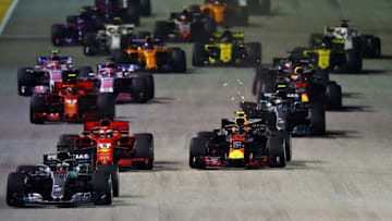 SINGAPORE - SEPTEMBER 16: Lewis Hamilton of Great Britain driving the (44) Mercedes AMG Petronas F1 Team Mercedes WO9 leads Sebastian Vettel of Germany driving the (5) Scuderia Ferrari SF71H, Max Verstappen of the Netherlands driving the (33) Aston Martin Red Bull Racing RB14 TAG Heuer and the rest of the field at the start during the Formula One Grand Prix of Singapore at Marina Bay Street Circuit on September 16, 2018 in Singapore. (Photo by Mark Thompson/Getty Images)