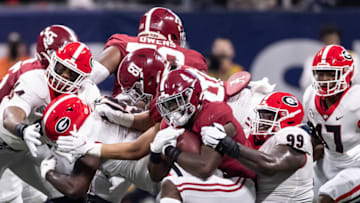 ATLANTA, GA - DECEMBER 4: Brian Robinson Jr. #4 of the Alabama Crimson Tide is tackled by Jordan Davis #99 of the Georgia Bulldogs during a game between Georgia Bulldogs and Alabama Crimson Tide at Mercedes-Benz Stadium on December 4, 2021 in Atlanta, Georgia. (Photo by Steven Limentani/ISI Photos/Getty Images)