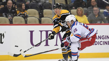 PITTSBURGH, PA - DECEMBER 20: Kasperi Kapanen #42 of the Pittsburgh Penguins attempts a shot as Ryan Lindgren #55 of the New York Rangers defends in the first period during the game at PPG PAINTS Arena on December 20, 2022 in Pittsburgh, Pennsylvania. (Photo by Justin Berl/Getty Images)