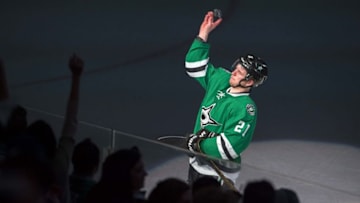 Apr 16, 2016; Dallas, TX, USA; Dallas Stars left wing Antoine Roussel (21) throws a puck to the crowd after being named the number three star in the win over the Minnesota Wild in game two of the first round of the 2016 Stanley Cup Playoffs at the American Airlines Center. The Stars defeat the Wild 2-1. Mandatory Credit: Jerome Miron-USA TODAY Sports