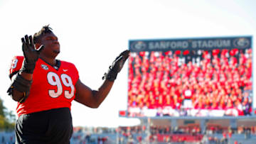 Jordan Davis of the Georgia Bulldogs leads the band after becoming an honorary member of the Georgia Bulldogs Redcoat Marching Band at the conclusion of the game against the Charleston Southern Buccaneers at Sanford Stadium on November 20, 2021 in Athens, Georgia. (Photo by Todd Kirkland/Getty Images)