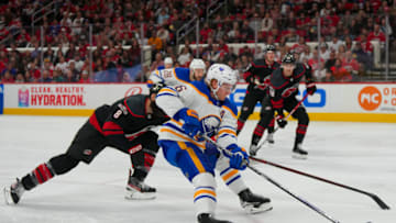 Nov 4, 2022; Raleigh, North Carolina, USA; Buffalo Sabres defenseman Rasmus Dahlin (26) cuts to the net past Carolina Hurricanes defenseman Brent Burns (8) during the second period at PNC Arena. Mandatory Credit: James Guillory-USA TODAY Sports
